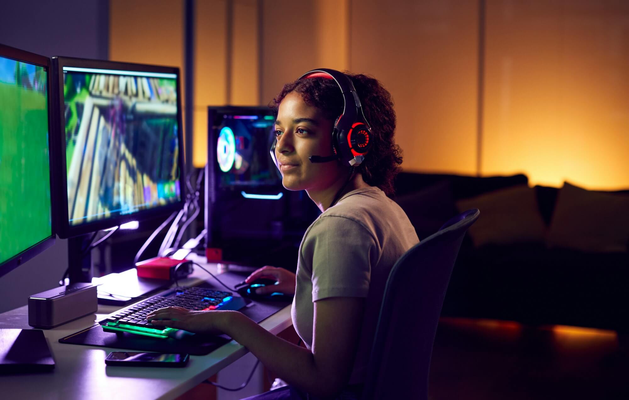 teenage-girl-wearing-headset-gaming-at-home-using-dual-computer-screens.jpg