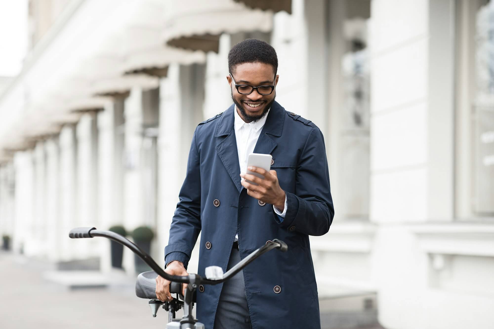 way-to-work-man-texting-on-phone-standing-with-bike.jpg